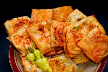 Siyah bir tabakta sambal ve arnavut biberli yumurta martabak ve reklam için boş alan..