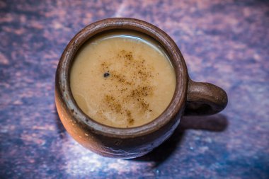 Güzel ışıklandırma arkaplanı ve reklam için boş yeri olan kilden bir fincanda kahve..