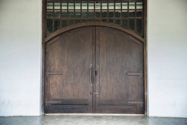 Tarihi bir binanın eski kapısı, beyaz duvarda izole edilmiş eski bir kapı..