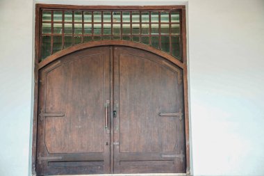 Tarihi bir binanın eski kapısı, beyaz duvarda izole edilmiş eski bir kapı..