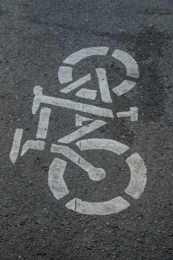 Asfalt zeminde bisiklet yolu tabelası, şehir yolunda beyaza boyanmış bisiklet tabelası, bisiklet kullanıcı şeridi tabelası.