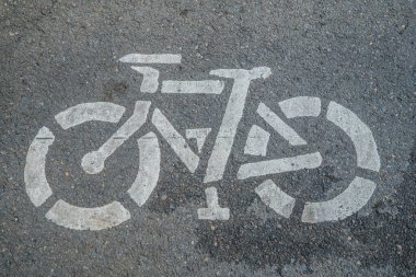 Asfalt zeminde bisiklet yolu tabelası, şehir yolunda beyaza boyanmış bisiklet tabelası, bisiklet kullanıcı şeridi tabelası.