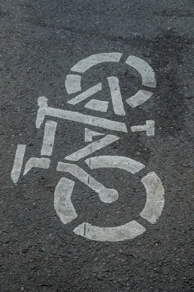 Asfalt zeminde bisiklet yolu tabelası, şehir yolunda beyaza boyanmış bisiklet tabelası, bisiklet kullanıcı şeridi tabelası.