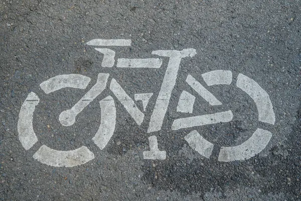 Asfalt zeminde bisiklet yolu tabelası, şehir yolunda beyaza boyanmış bisiklet tabelası, bisiklet kullanıcı şeridi tabelası.