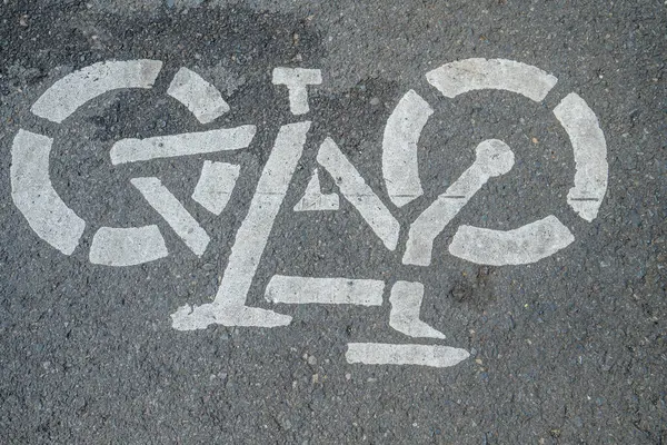 Asfalt zeminde bisiklet yolu tabelası, şehir yolunda beyaza boyanmış bisiklet tabelası, bisiklet kullanıcı şeridi tabelası.