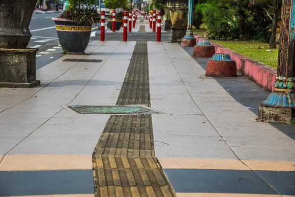 Kör kullanıcılar için ziyaret edilen dokulu yolları olan yayalar için şehir kaldırımının görünümü.