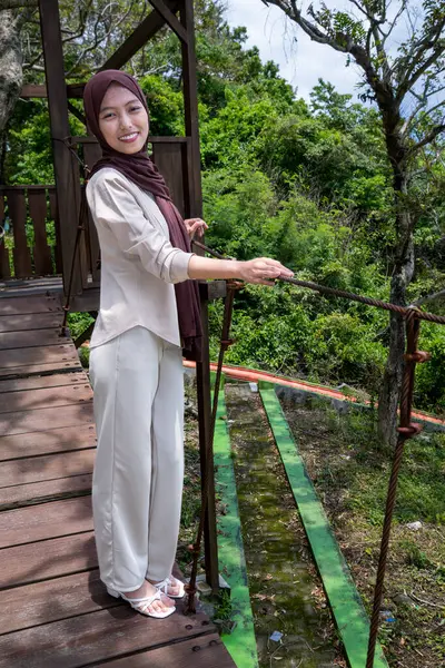 Asyalı kadınlar, halata bağlı ahşap bir köprüde, orman parkında tatil kavramının üzerinde dururlar..