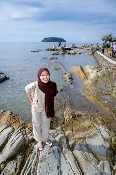 Müslüman Asyalı Kadınlar Deniz Taşı 'nın üzerinde duruyor. Reklam için boş bir alan var.