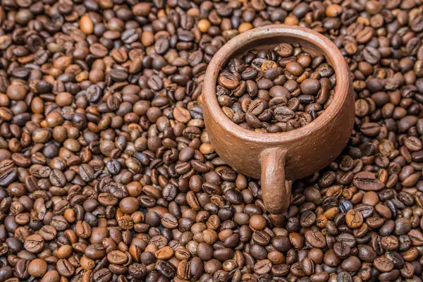 Kahve çekirdeklerine yakın çekim, kahve çekirdekleri ve kahve çekirdekleri arasındaki kahve çekirdekleri, toprak kankir izole kahve çekirdekleri.