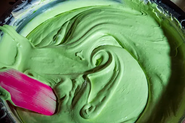Renk verildiğinde karıştırılan kek karışımı yeşil ekmek için hamuru karıştırıyor..