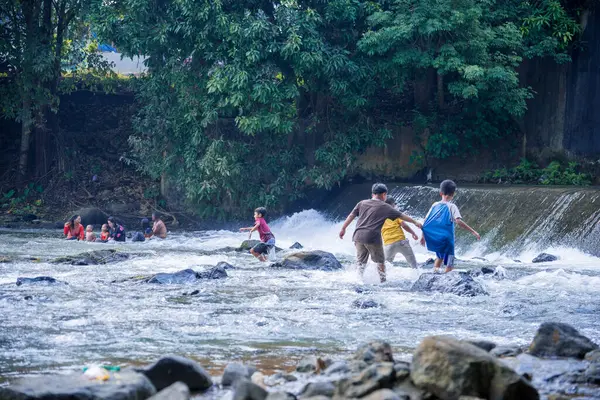 Jepara Central Java, 7 Nisan 2025, nehirde oynayan çocuklar, nehirde su oynayan çocukların heyecanı..