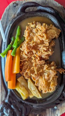 Kızarmış tavuk bifteği. Kahverengi sos, havuç ve yeşil fasulye karışımı.