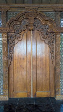 Geleneksel Cava binası cephesi detaylı ahşap oymalarla dolu, geleneksel bir Java ahşap binasının ön manzarası..