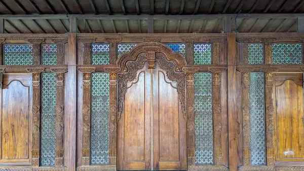 Geleneksel Cava binası cephesi detaylı ahşap oymalarla dolu, geleneksel bir Java ahşap binasının ön manzarası..