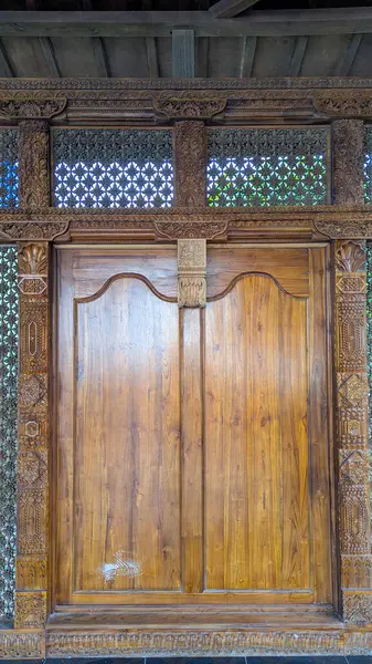 Geleneksel Cava binası cephesi detaylı ahşap oymalarla dolu, geleneksel bir Java ahşap binasının ön manzarası..