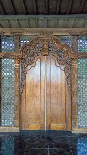 Geleneksel Cava binası cephesi detaylı ahşap oymalarla dolu, geleneksel bir Java ahşap binasının ön manzarası..