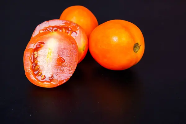 Domatesler kesilmiş ve reklamlar için siyah üzerine kısmen el değmemiş..