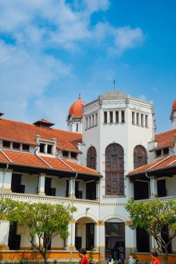 Lawang Sewu 'nun tipik bir Hollanda mimarisi olan kırmızı çatılı tarihi binası mavi gökyüzünün altında reklam odası için muhteşem görünüyor..