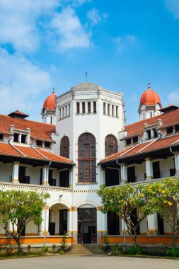 Lawang Sewu 'nun tipik bir Hollanda mimarisi olan kırmızı çatılı tarihi binası mavi gökyüzünün altında reklam odası için muhteşem görünüyor..