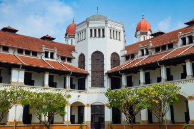 Lawang Sewu 'nun tipik bir Hollanda mimarisi olan kırmızı çatılı tarihi binası mavi gökyüzünün altında reklam odası için muhteşem görünüyor..