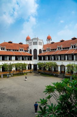 Lawang Sewu 'nun tipik bir Hollanda mimarisi olan kırmızı çatılı tarihi binası mavi gökyüzünün altında reklam odası için muhteşem görünüyor..