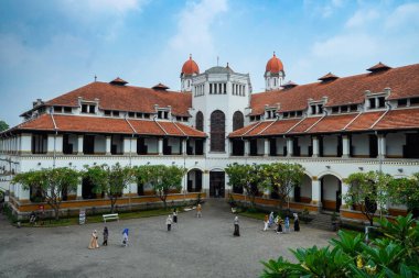 Lawang Sewu 'nun tipik bir Hollanda mimarisi olan kırmızı çatılı tarihi binası mavi gökyüzünün altında reklam odası için muhteşem görünüyor..