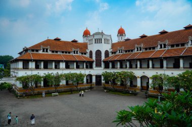 Lawang Sewu 'nun tipik bir Hollanda mimarisi olan kırmızı çatılı tarihi binası mavi gökyüzünün altında reklam odası için muhteşem görünüyor..