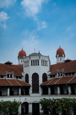 Lawang Sewu 'nun tipik bir Hollanda mimarisi olan kırmızı çatılı tarihi binası mavi gökyüzünün altında reklam odası için muhteşem görünüyor..