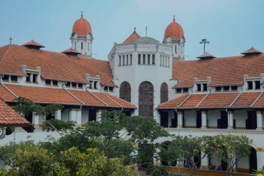 Lawang Sewu 'nun tipik bir Hollanda mimarisi olan kırmızı çatılı tarihi binası mavi gökyüzünün altında reklam odası için muhteşem görünüyor..
