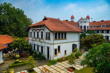Lawang Sewu 'nun tipik bir Hollanda mimarisi olan kırmızı çatılı tarihi binası mavi gökyüzünün altında reklam odası için muhteşem görünüyor..