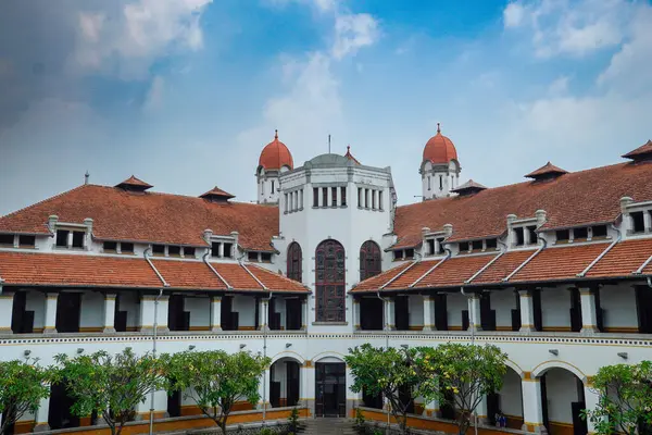 Lawang Sewu 'nun tipik bir Hollanda mimarisi olan kırmızı çatılı tarihi binası mavi gökyüzünün altında reklam odası için muhteşem görünüyor..