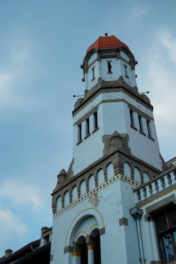 Kırmızı kubbe şeklinde çatısı olan yüksek bir bina reklam alanı için arka planda parlak mavi gökyüzü ile alçak bir açıdan görünüyor..