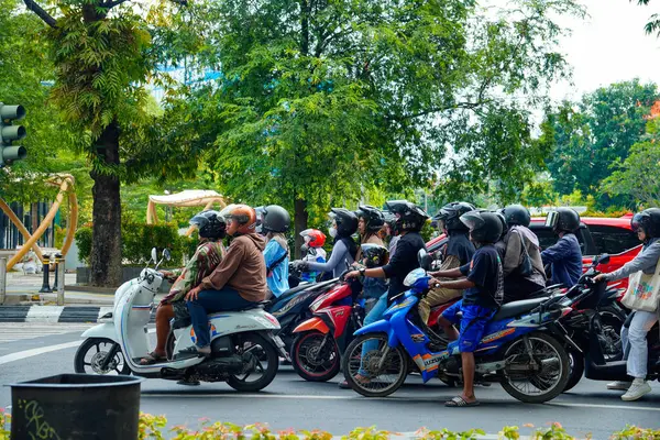 Semarang, Merkez Java, 1 Mayıs 2025, bir kavşakta durup trafik ışıklarını bekleyen bir motosiklet sürücüsü..