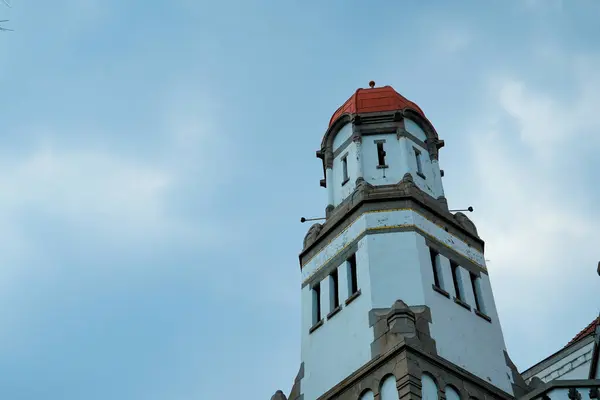 Kırmızı kubbe şeklinde çatısı olan yüksek bir bina reklam alanı için arka planda parlak mavi gökyüzü ile alçak bir açıdan görünüyor..