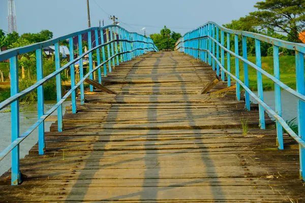 Tahta köprü ve nehri kaplayan korkuluklar. Nehir üzerindeki ahşap köprünün yüzey hasarı bozulmaya başladı..