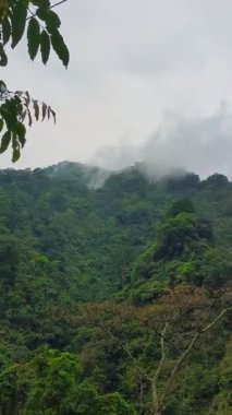 Dağlık vadilerde yerleşim yerleri olan koni şeklindeki yüksek dağların manzarası.