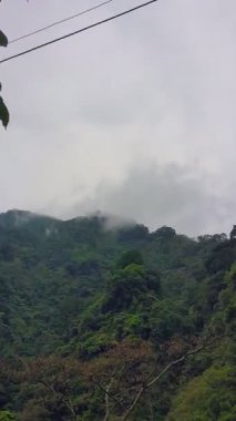 Dağlık vadilerde yerleşim yerleri olan koni şeklindeki yüksek dağların manzarası.