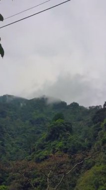 Dağlık vadilerde yerleşim yerleri olan koni şeklindeki yüksek dağların manzarası.