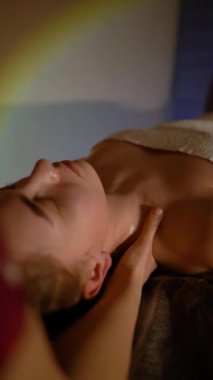 Kozmetik salonundaki usta bir masör genç ve güzel bir kıza masaj yapar. Yakın çekim eller deriyi ve bedeni yağla değiştirir. Mumlarla kaplı karanlık bir ofis.