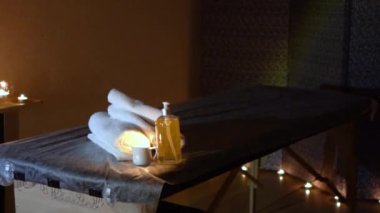 Kozmetik salonundaki usta bir masör masaj yapar, yakın çekim yağı, mumlarla dolu karanlık bir ofis.