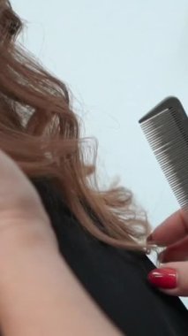 Güzellik kuaförü bir güzellik salonunda kız müşterisine saç yapıyor. Eller ve iplikler yakın planda. Yüksek kaliteli görüntüler