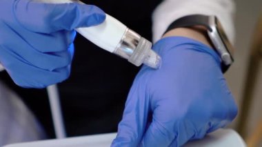 Kıl temizleme ustası, çeşitli cihazlar ve manipülatör kullanarak genç bir müşteriye tüy yolma işlemi yapar. Kadın güzelliği ve kozmetik ürünleri için güzellik salonu. Yüksek kalite 4k görüntü