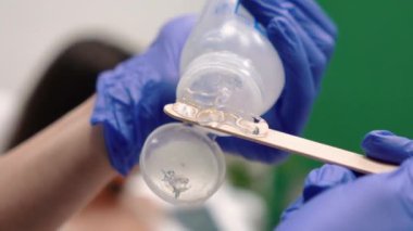 Güzellik hocası, güzel, dikenli dudaklı gözlüklü bir kız için güzellik salonuna yakın çekimde lazerle bacak kesiyor. Yüksek kaliteli FullHD görüntüler