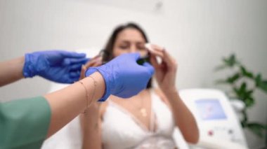 Beyaz dantelli iç çamaşırlı, genç ve güzel bir kız güzellik salonunda saç çıkarma uzmanıyla resepsiyonda gözlük takıyor.