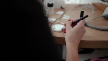 Güzellik ustası manikürcü, güzellik salonunda genç ve güzel bir kıza el ve parmaklarıyla manikür yapıyor. Tamirci aletlerini kapatın. Yüksek kaliteli FullHD görüntüler