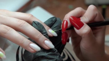 Güzellik ustası manikürcü, güzellik salonunda genç ve güzel bir kıza el ve parmaklarıyla manikür yapıyor. Tamirci aletlerini kapatın. Yüksek kaliteli FullHD görüntüler