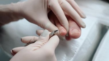 Pedikür ustası, küçük ayaklı güzel bir kıza temizlik ve masaj yapar. Bir prosedür sırasında güzellik salonunda kadın güzelliğiyle ilgilenmek. Ayak ve ayak parmaklarının derisi yakın plan. Yüksek