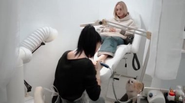 Pedikür ustası, küçük ayaklı güzel bir kıza temizlik ve masaj yapar. Bir prosedür sırasında güzellik salonunda kadın güzelliğiyle ilgilenmek. Ayak ve ayak parmaklarının derisi yakın plan. Yüksek