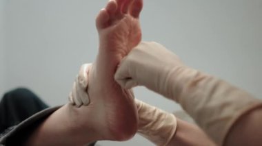 Pedikür ustası, küçük ayaklı güzel bir kıza temizlik ve masaj yapar. Bir prosedür sırasında güzellik salonunda kadın güzelliğiyle ilgilenmek. Ayak ve ayak parmaklarının derisi yakın plan. Yüksek