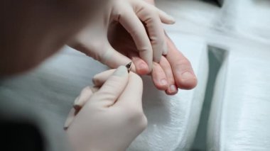 Pedikür ustası, küçük ayaklı güzel bir kıza temizlik ve masaj yapar. Bir prosedür sırasında güzellik salonunda kadın güzelliğiyle ilgilenmek. Ayak ve ayak parmaklarının derisi yakın plan. Yüksek